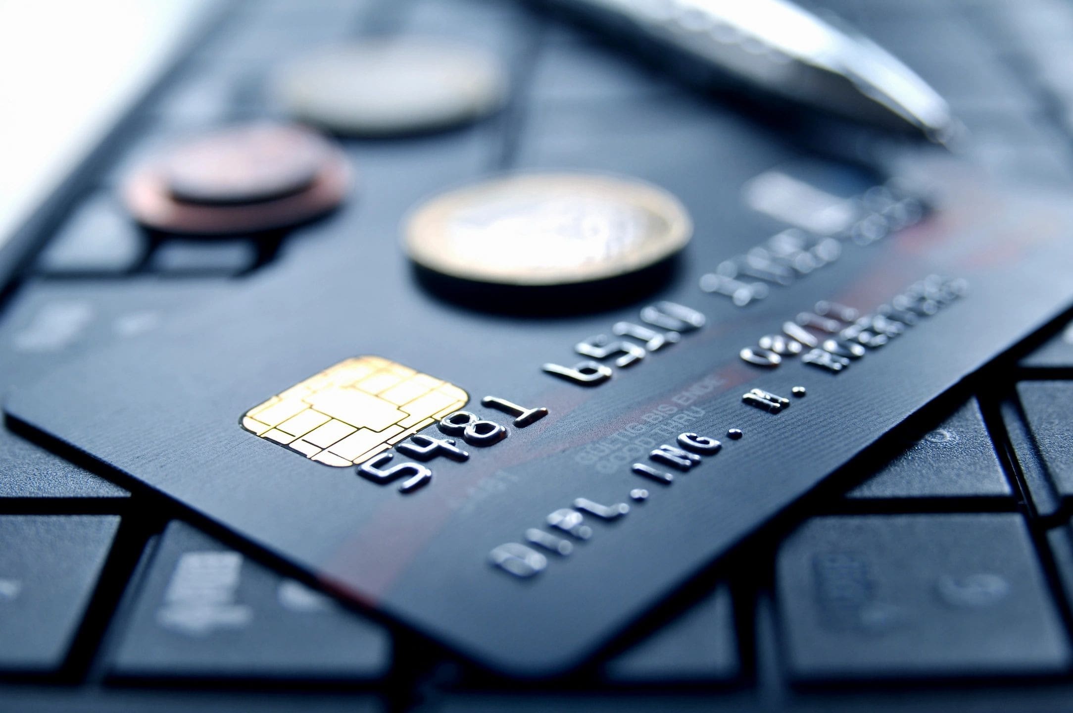 A close up of a credit card and some coins