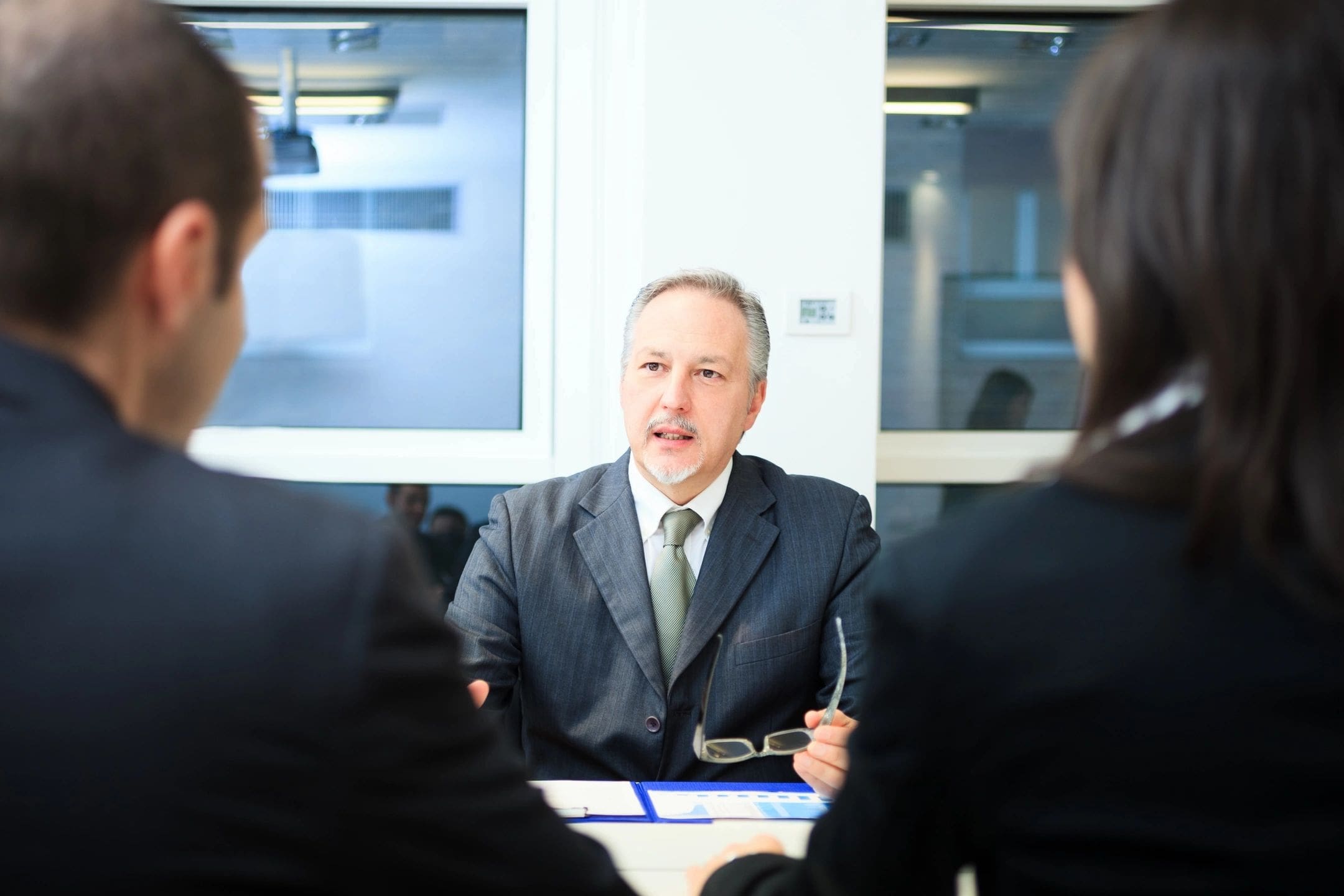 A man in suit and tie sitting at a table.