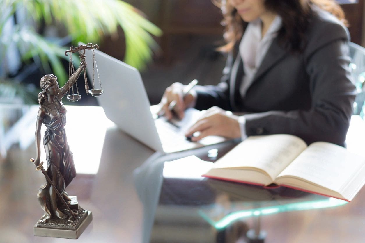 A woman sitting at a table with a laptop.